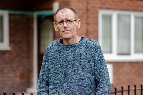 Lee standing in front of a house